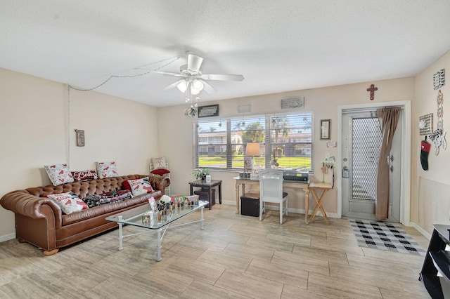 living room with ceiling fan, light hardwood / wood-style floors, and a textured ceiling