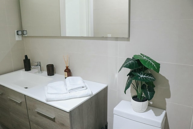 bathroom with tasteful backsplash, toilet, and tile walls