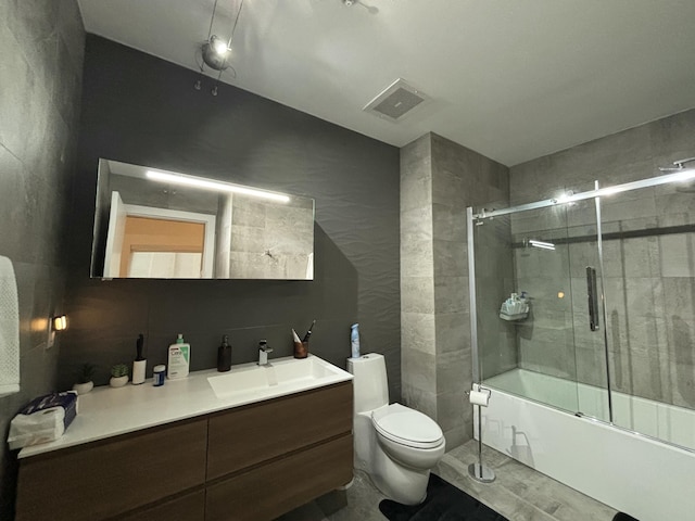 full bathroom featuring vanity, toilet, and combined bath / shower with glass door