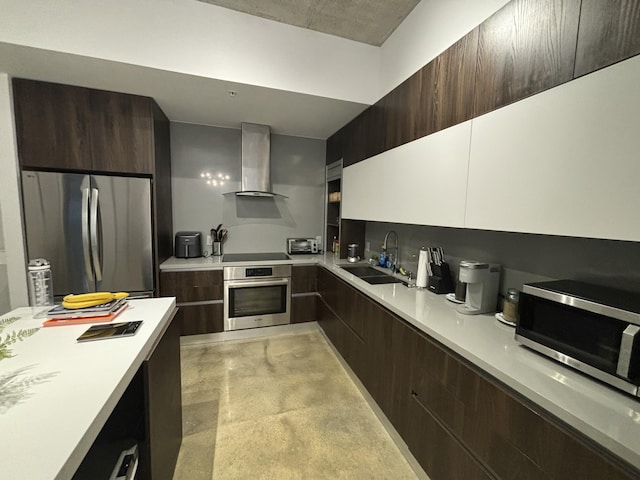 kitchen featuring sink, wall chimney exhaust hood, dark brown cabinets, and appliances with stainless steel finishes