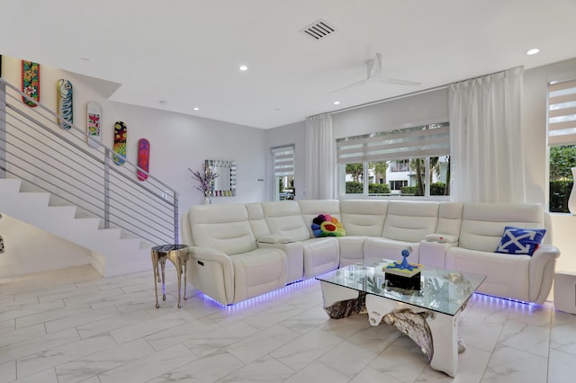 living room featuring ceiling fan and a wealth of natural light