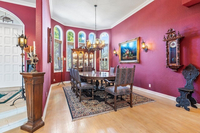 dining room featuring crown molding, wood-type flooring, a textured ceiling, and a chandelier