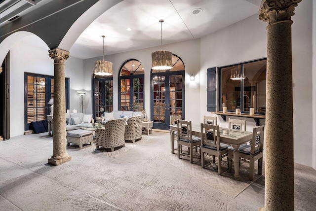 dining room featuring a notable chandelier, french doors, a high ceiling, and ornate columns