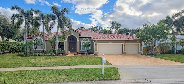 mediterranean / spanish-style home featuring a garage and a front lawn