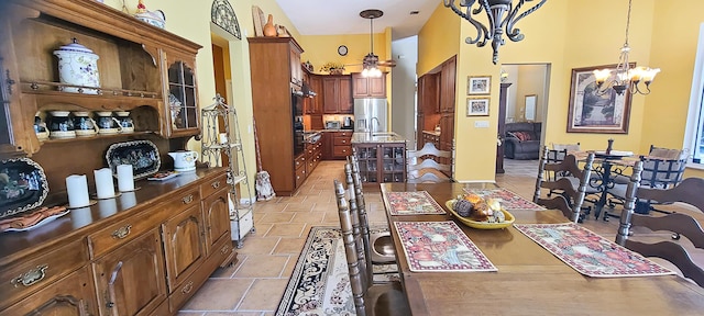 dining room with sink, a towering ceiling, and an inviting chandelier