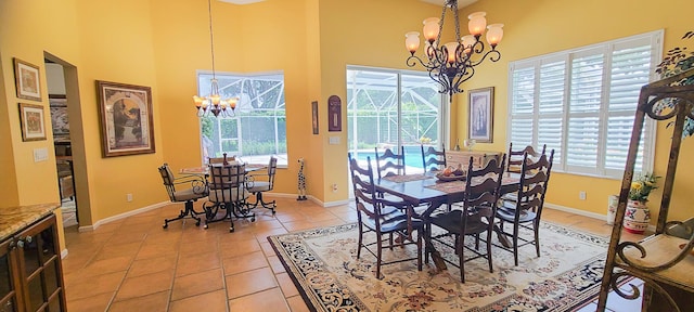 dining space with a towering ceiling, light tile patterned floors, and a chandelier