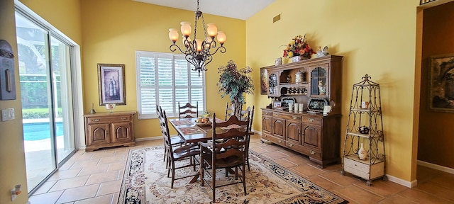 tiled dining area with a healthy amount of sunlight, high vaulted ceiling, and a chandelier