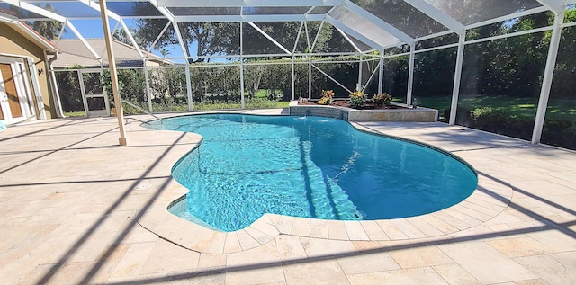 view of pool featuring glass enclosure and a patio