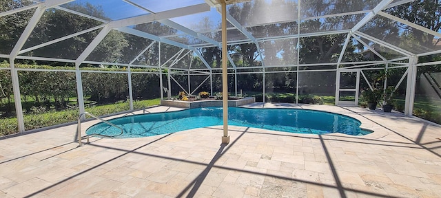 view of pool with glass enclosure and a patio