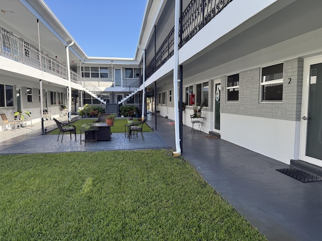 view of property's community with a yard and a patio