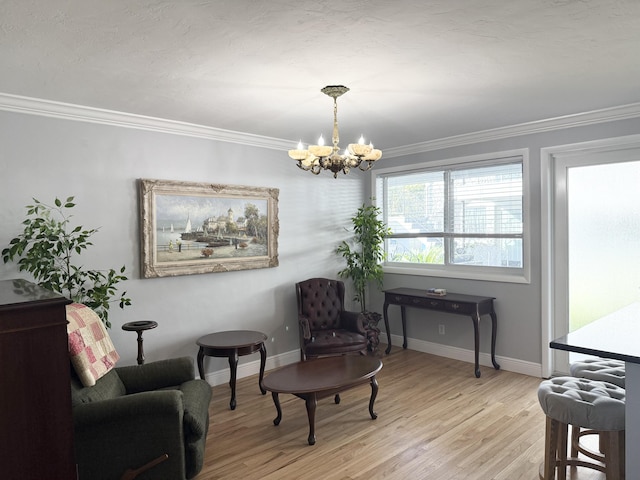 sitting room with light hardwood / wood-style floors, crown molding, and an inviting chandelier