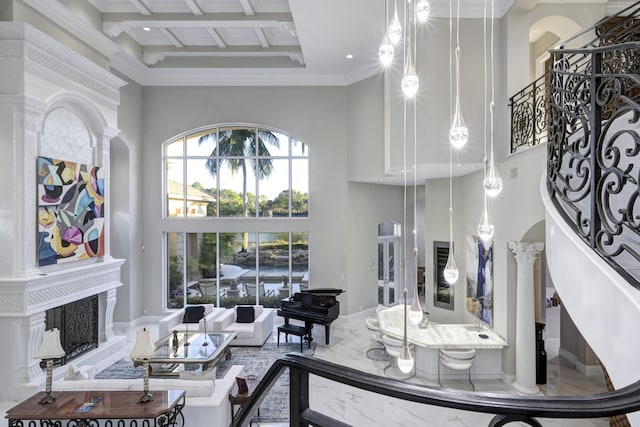 living room with coffered ceiling, beamed ceiling, decorative columns, crown molding, and a towering ceiling