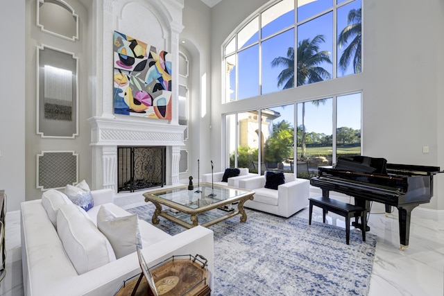 living area with a towering ceiling and a large fireplace