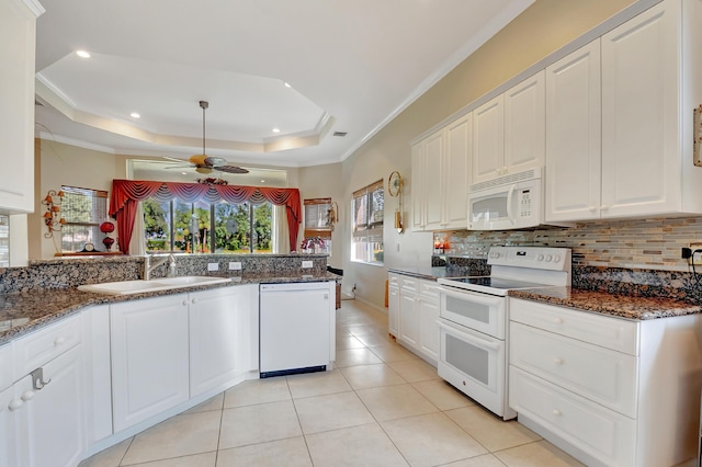 kitchen featuring white cabinetry, white appliances, and dark stone counters