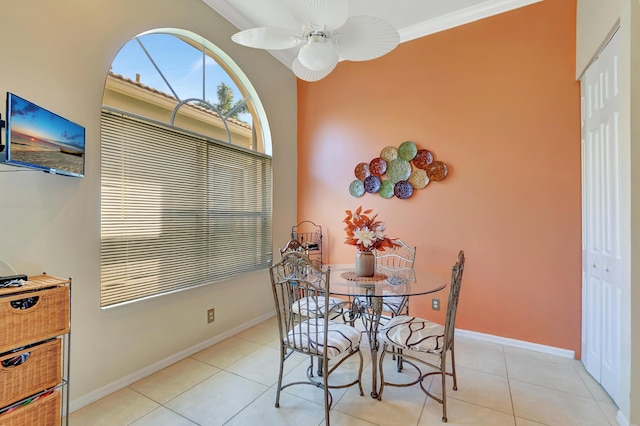 tiled dining room with ceiling fan and crown molding