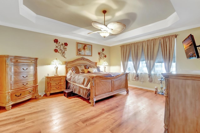 bedroom with a raised ceiling, ceiling fan, light hardwood / wood-style flooring, and crown molding