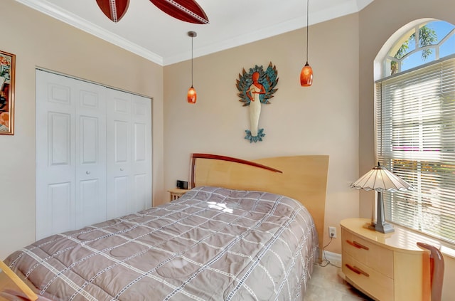 bedroom featuring ceiling fan, a closet, and crown molding