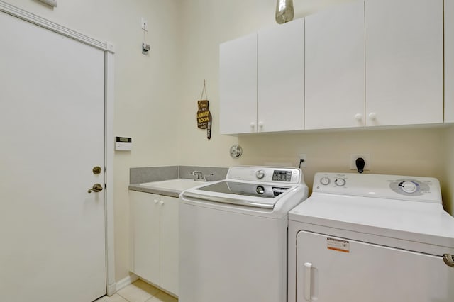 washroom featuring cabinets, independent washer and dryer, light tile patterned floors, and sink