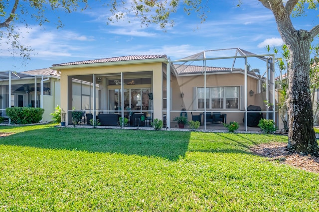 back of property featuring a lawn and glass enclosure