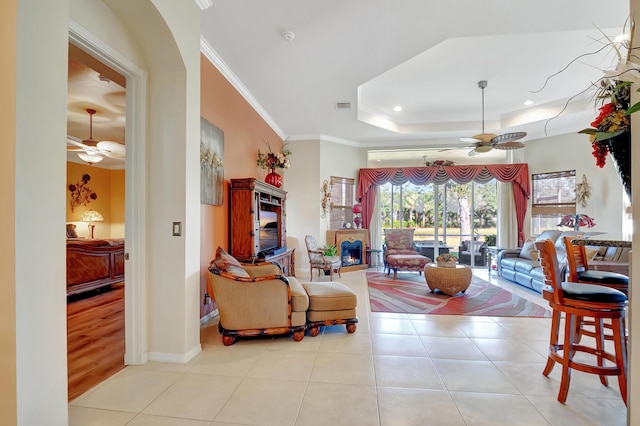 living room with light hardwood / wood-style floors, ceiling fan, and crown molding