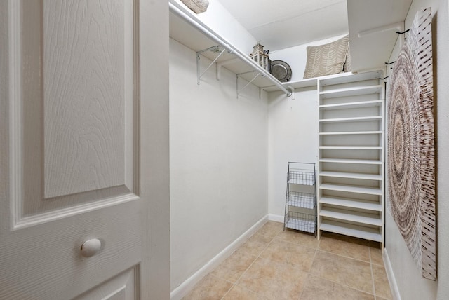 walk in closet with light tile patterned flooring