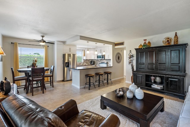 living room with ceiling fan and sink