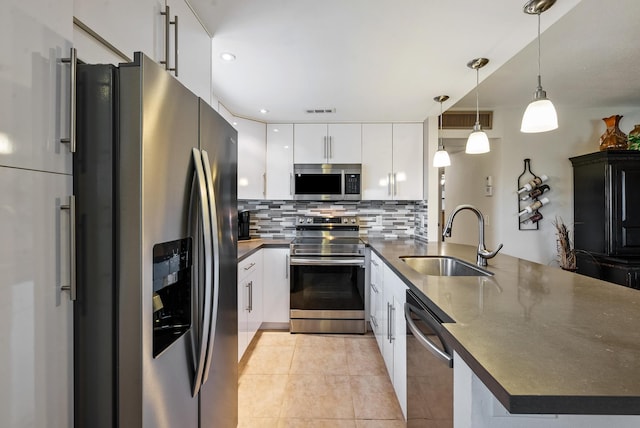 kitchen with tasteful backsplash, stainless steel appliances, sink, pendant lighting, and white cabinetry