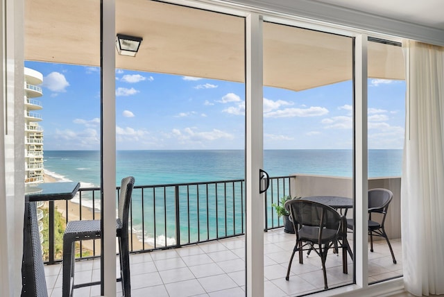 interior space featuring a view of the beach, a water view, and a wealth of natural light