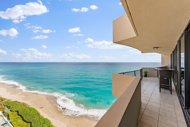 balcony featuring a water view and a view of the beach