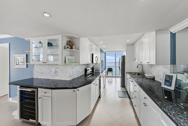 kitchen featuring white cabinetry, sink, beverage cooler, tasteful backsplash, and appliances with stainless steel finishes