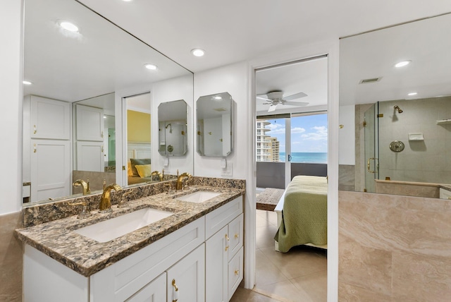 bathroom with ceiling fan, tile patterned flooring, a water view, a shower with door, and vanity