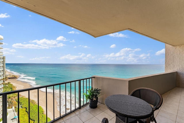 balcony with a water view and a view of the beach