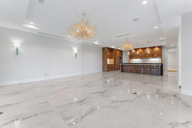 unfurnished living room featuring sink and an inviting chandelier