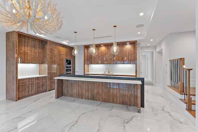 kitchen featuring decorative light fixtures, a kitchen island, sink, and appliances with stainless steel finishes