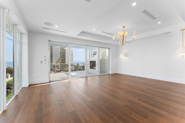 unfurnished room with hardwood / wood-style flooring and an inviting chandelier