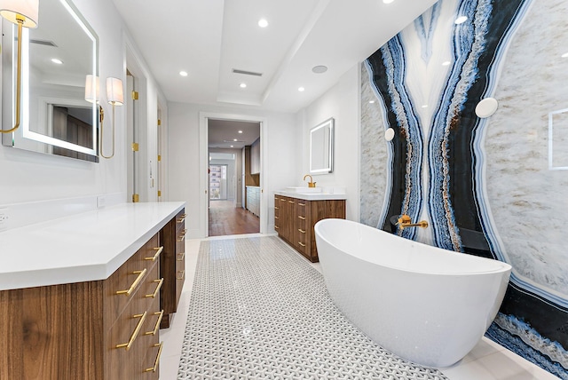 bathroom with vanity, wood-type flooring, and a tub