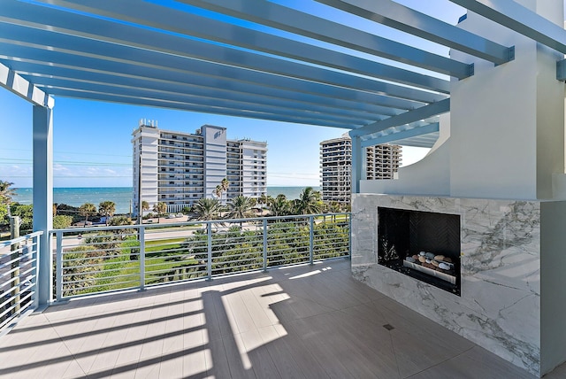 wooden deck featuring a high end fireplace and a water view