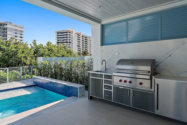 view of pool featuring sink, grilling area, and exterior kitchen