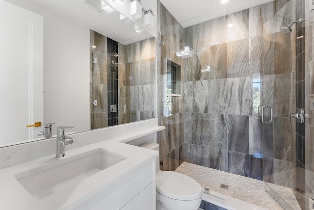 bathroom with toilet, an enclosed shower, and vanity