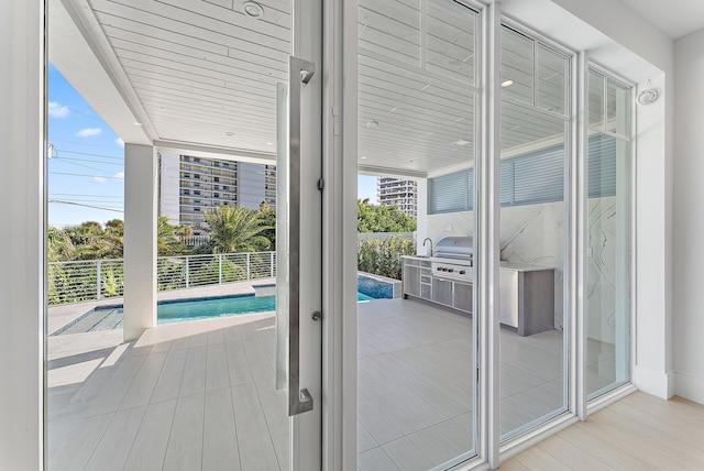 doorway with light hardwood / wood-style floors and floor to ceiling windows