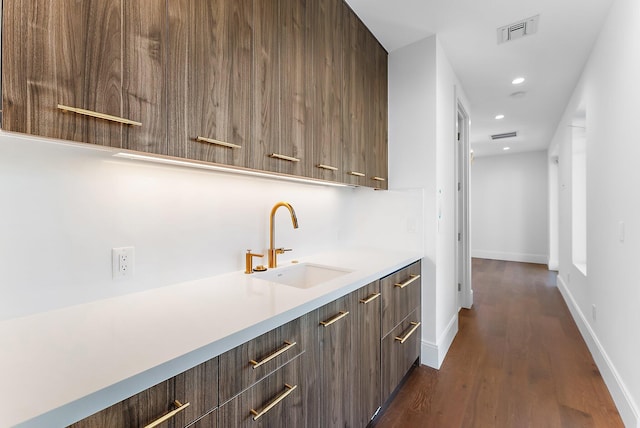 bar featuring dark hardwood / wood-style flooring and sink