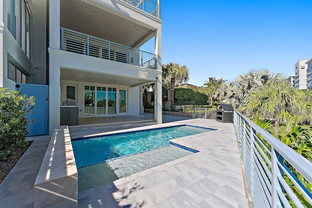 view of pool with area for grilling, a patio area, and exterior kitchen