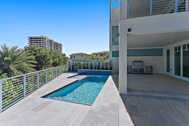 view of swimming pool with an outdoor kitchen, grilling area, and a patio area