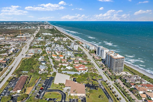 drone / aerial view with a water view and a beach view