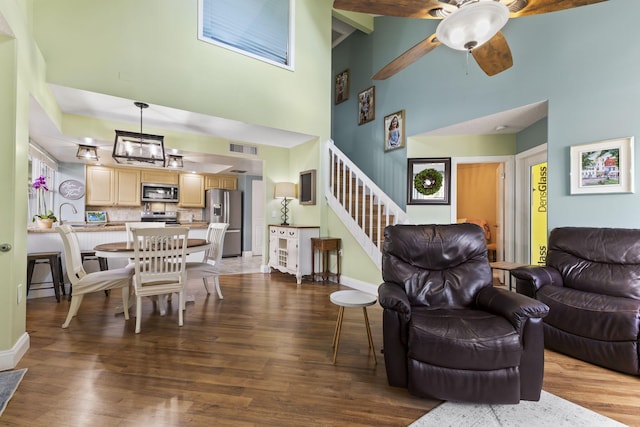 living room with beam ceiling, high vaulted ceiling, ceiling fan, and wood-type flooring