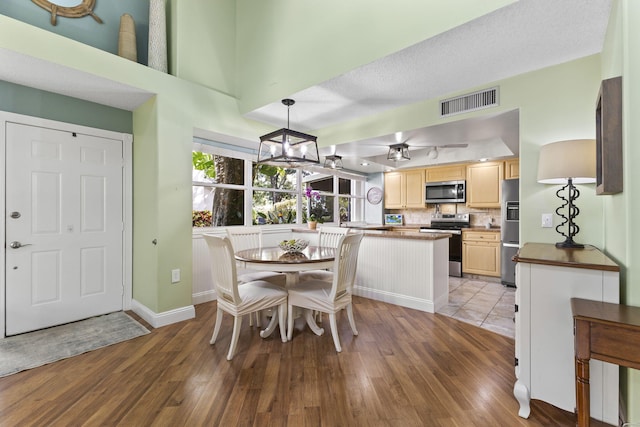 dining space featuring a chandelier, a textured ceiling, and light hardwood / wood-style flooring