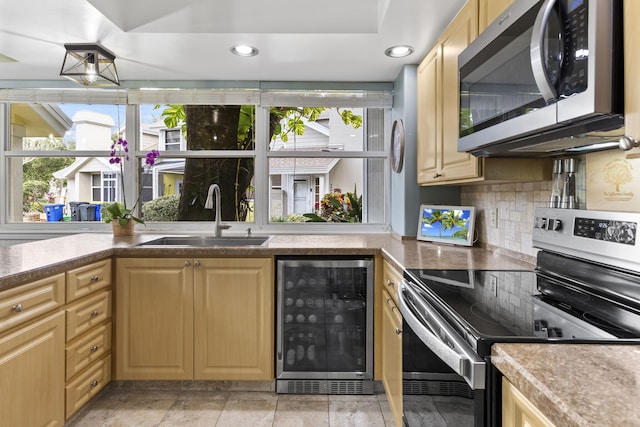 kitchen with light brown cabinets, sink, stainless steel appliances, and beverage cooler