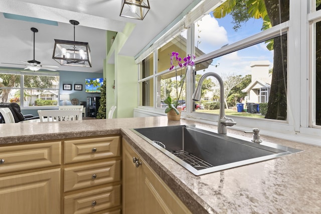 kitchen featuring a wealth of natural light, decorative light fixtures, ceiling fan, and sink