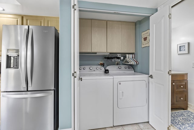 clothes washing area with cabinets, independent washer and dryer, and light tile patterned flooring