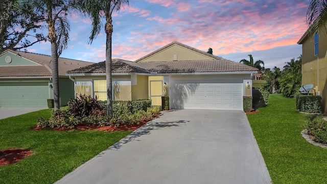 view of front of property with a garage and a lawn